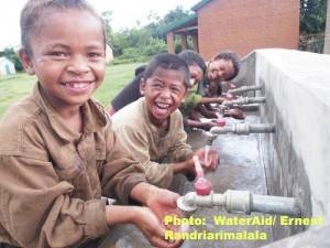 Pupils Dahery, 8 and Tiana, 8,and their friends  washing their faces in the new handwashing facility of the Catholic school in the village of Manaotaonkafa, Commune Andranomafana, Betafo District, Vakinankaratra region, Madagascar