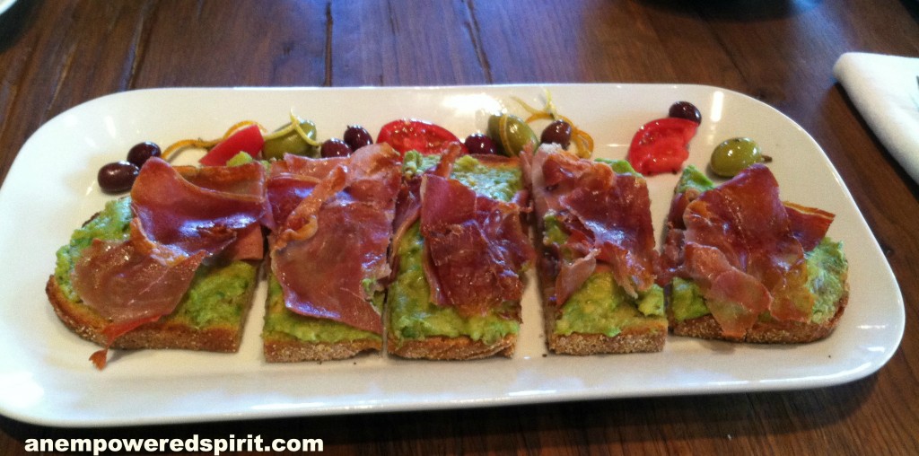 Guacamole topped with Serrano ham on top of homemade hearth bread